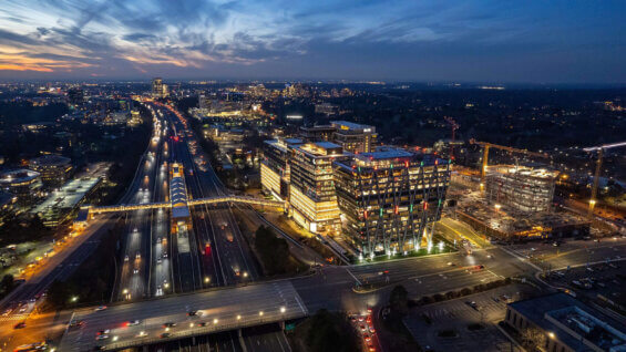 A highway and buildings at dusk are brightly lit in Reston, Virginia.