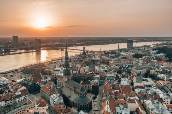 Sunset lights up a city on a riverfront in Europe.