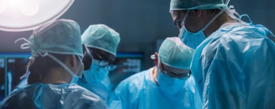 Four surgeons perform a procedure in a hospital.