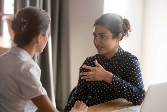 A young Indian businesswoman speaks to a colleague.